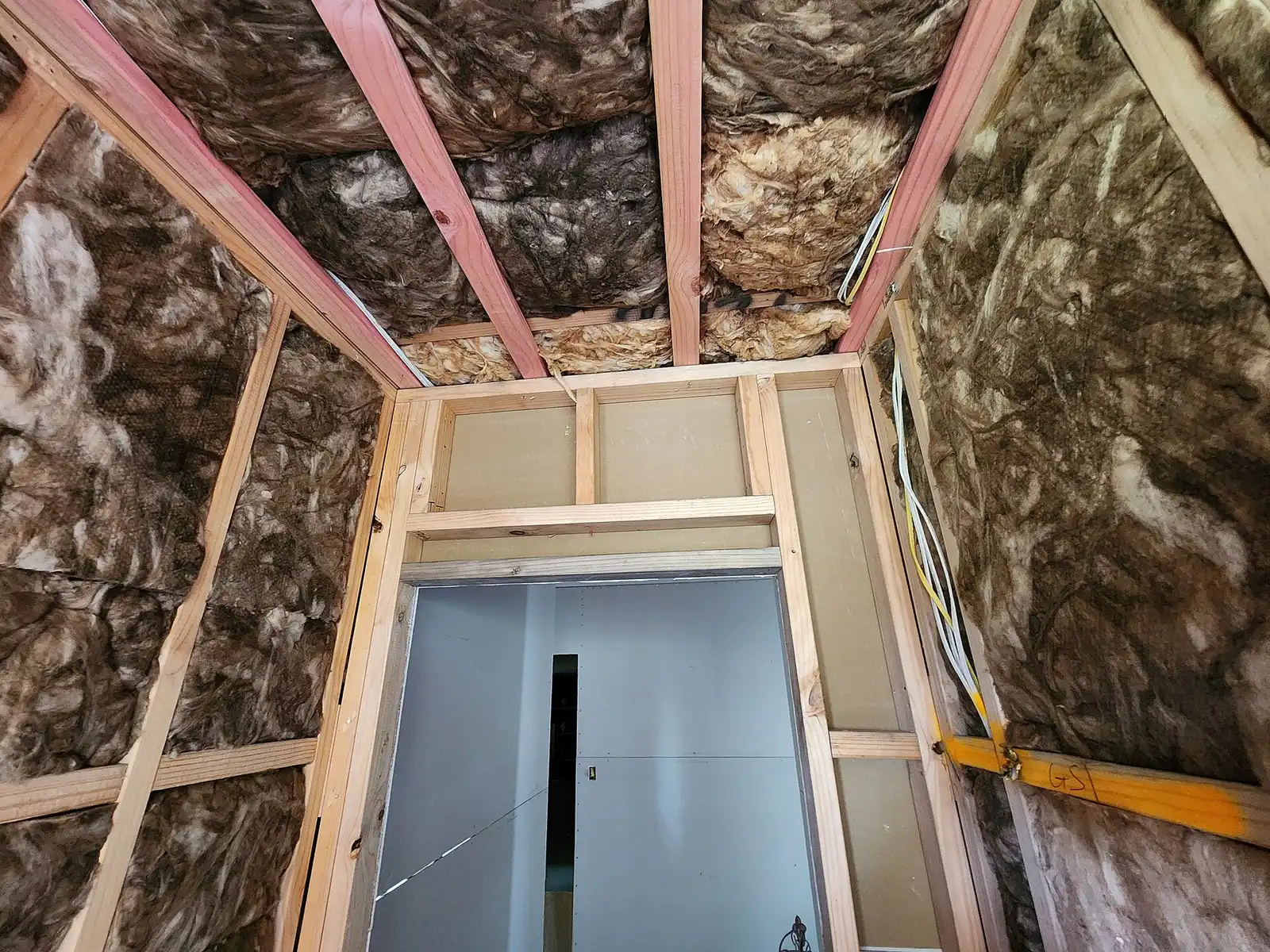 Insulated walls and ceiling in a framed room before drywall